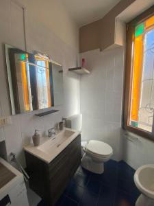Baño blanco con aseo y lavamanos en Appartamento Homemade, en Biella