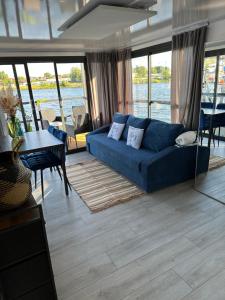 - un salon avec un canapé bleu et une table dans l'établissement Premium Hausboot Trave Traum, à Lübeck