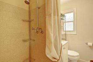 y baño con ducha, aseo y cortina de ducha. en Spanish Village Cottage w private cabana, en Port Aransas 15 fotos más