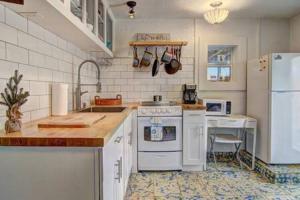 Una cocina con electrodomésticos blancos y un refrigerador blanco. en Spanish Village Sunshine Cottage, en Port Aransas