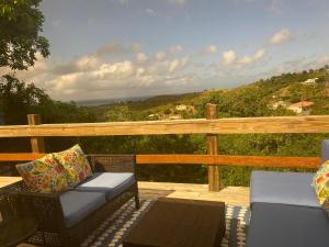 a patio with two chairs and a table on a deck at Estate Lowry Hill in Christiansted