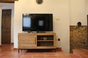 una TV a schermo piatto seduta sopra un centro di intrattenimento in legno di Alojamiento turistico LaVid a Requena