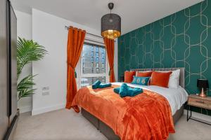 a bedroom with a bed with orange and green walls at Luxury Apartment-Free Parking-Central Location in Luton