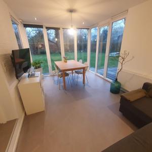 ein Wohnzimmer mit einem Tisch und einem Sofa in der Unterkunft Zelfstandig gastenverblijf in het groene Haren nabij Groningen in Haren (Ems)