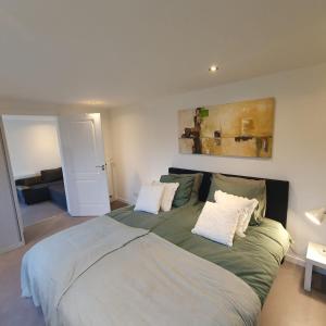 um quarto com uma cama grande e 2 almofadas em Zelfstandig gastenverblijf in het groene Haren nabij Groningen em Haren