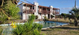 a house with a swimming pool in front of a house at Serena Aparts in La Paloma