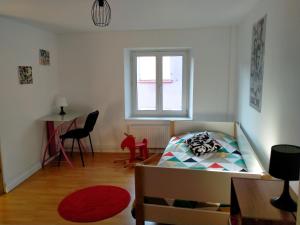 um quarto com uma cama, uma mesa e uma janela em La Casa de Pimpele em Saint-Martin