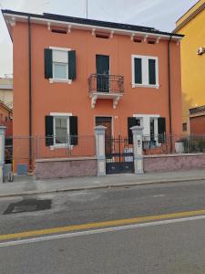 un edificio naranja al lado de una calle en La Maison di Luca, en Verona