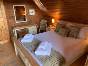 a bedroom with a bed in a wooden cabin at Horsey Reach Lodge in Stanley