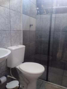 uma casa de banho com um WC branco e um lavatório. em Chalé Triunfo em Triunfo