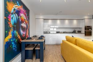a living room with a table and a yellow couch at Luxury Apartment-Free Parking-Central Location-Close To Airport, Station & Centre in Luton