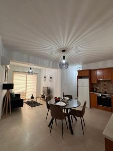 Una cocina y una sala de estar con mesa y sillas. en Lucy's holidays apartment, en Peyia