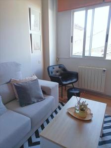 een woonkamer met een bank en een tafel bij Apartamento Sobreira en centro Allariz con WIFI in Allariz