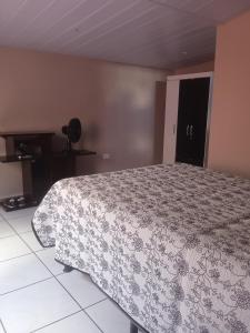 a bedroom with a bed with a flowered blanket at Chalé Triunfo in Triunfo