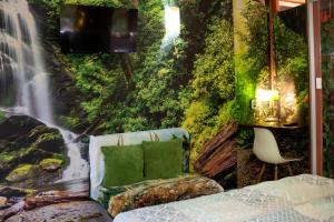 a bed in a room with a waterfall mural at Coyote Rooms in Cabuya