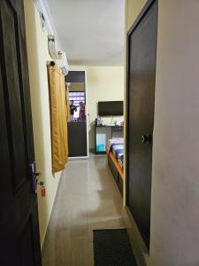 a hallway with a room with a bed and a door at Joys Stay in Trichūr
