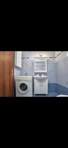 a bathroom with a washing machine and a sink at Cozy apartment next to the port! in Piraeus