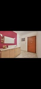 a large room with red walls and a wooden door at Cozy apartment next to the port! in Piraeus