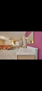 a kitchen with purple walls and a white counter top at Cozy apartment next to the port! in Piraeus