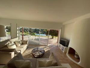 a living room with a couch and a tv at GARBE - Private Villa,Total Privacy, Infinity Swimming Pool, Close to Beaches in Porches