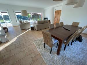 a living room with a wooden table and chairs at GARBE - Private Villa,Total Privacy, Infinity Swimming Pool, Close to Beaches in Porches