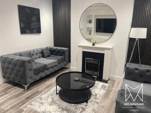 a living room with a couch and a mirror at DULEX ROOMS in Scunthorpe