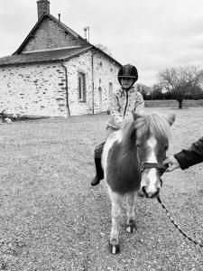 a person riding a miniature pony with a person holding it at Le Domaine du Nail in Mée