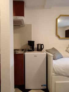 a small kitchen with a white refrigerator next to a bed at Lamar in Cres