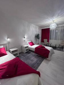 a bedroom with two beds with red and white sheets at BlueSolarPearl R - Vaihtoehto majoittumiselle in Nokia