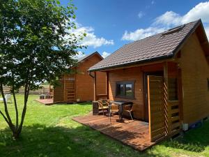 a log cabin with a table and chairs on a deck at "OhMazury" ogród i winnica in Giżycko