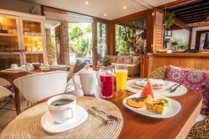 uma mesa com uma chávena de café e um prato de comida em Pousada Agua de Coco em Arraial d'Ajuda