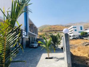 una casa con una palma accanto a una strada di Edificio Cosec Hotel a Cova Figueira