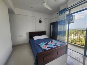 - une chambre avec un lit et une grande fenêtre dans l'établissement Two bedroom apartment in Colombo, à Talawatugoda