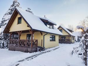 a house with a snow covered roof at Domki Spokojny Zakątek in Lipowa