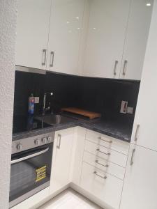 een witte keuken met een wastafel en een fornuis bij Ferienwohnung/Montagewohnung 2 in Bad Driburg