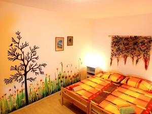 a bedroom with a bed with a tree mural on the wall at Hotel Zemlinski in Payerbach