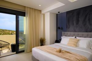 a bedroom with a large bed and a balcony at KALOS LUXURY HOMES, BEACHSIDE EXPERIENCE VOULISMA in Istron +74 photos