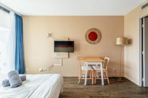 a bedroom with a desk and a table and a bed at Bord de mer! Studio Terrasse ,Prado Plage in Marseille