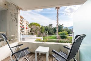 a balcony with chairs and a table and a large window at Bord de mer! Studio Terrasse ,Prado Plage in Marseille