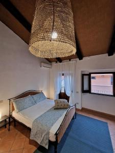 シッラにあるLA CASETTA AZZURRA CHIANALEA - locazione turisticaのベッドルーム1室(ベッド1台、大きなシャンデリア付)