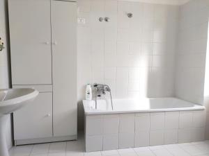 ein weißes Badezimmer mit einer Badewanne und einem Waschbecken in der Unterkunft La Casina di Enea in Cascia