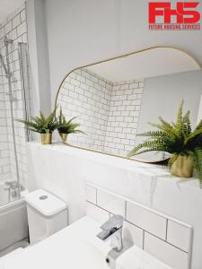 a white bathroom with a mirror and a sink at Digbeth Luxury Apartment in Birmingham