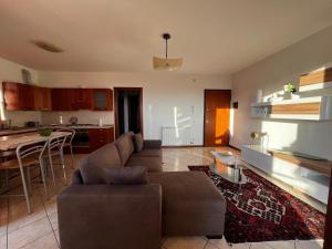 a living room and kitchen with a couch and a table at "IL VIGNETO" Apartment in Negrar