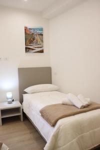 a bedroom with two beds and a painting on the wall at Casa Lu Mari in Sciacca