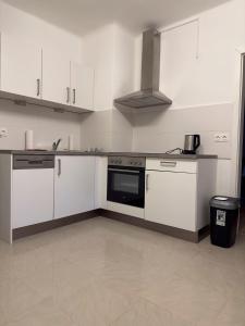 a kitchen with white cabinets and a stove top oven at Ferienwohnung in Reichenau an der Rax in Reichenau
