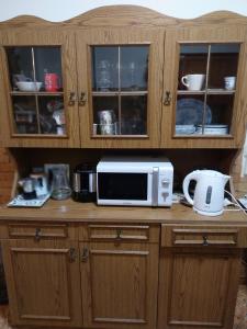 a microwave sitting on top of a wooden cabinet at HARMÓNIA HÁZ in Makó