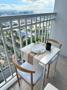 a white table and chairs on a balcony with a view at Condo Unit near MOA, PICC, US Embassy and Airport in Manila