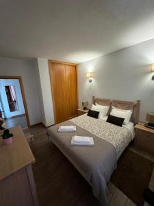 a bedroom with a large bed with two towels on it at Apartamento Oceano in Albufeira