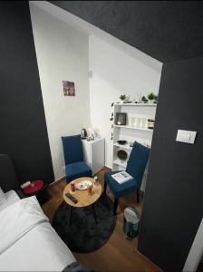 um quarto com uma cama, duas cadeiras e uma mesa em London.Apartments em Pristina