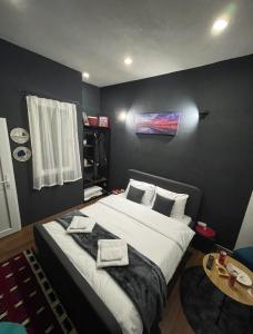 um quarto com uma cama grande com duas toalhas em London.Apartments em Pristina